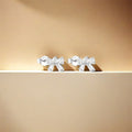 dainty bow shaped stud earrings in gold plated sterling silver made with zirconia crystals