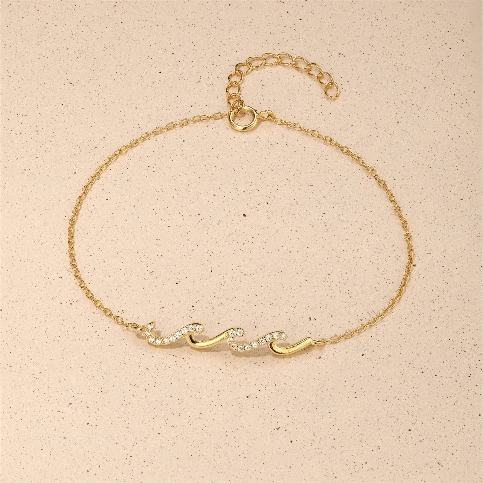 Gold bracelet with wave-shaped zircon design centerpiece on a sterling silver chain, finished with 18K gold plating.