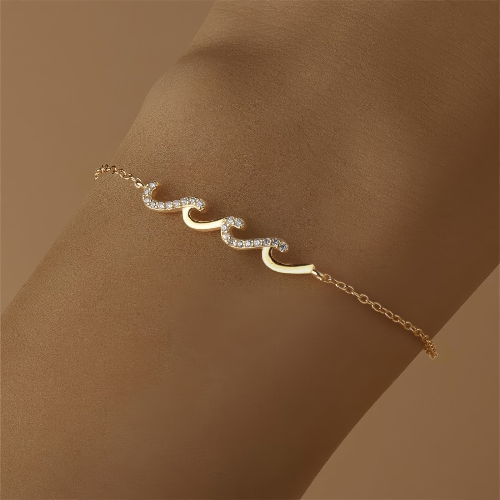 Gold bracelet with wave-shaped zircon design centerpiece on a sterling silver chain, finished with 18K gold plating.