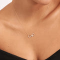 infinity knot necklace hands holding crystal heart