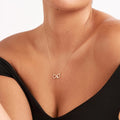 infinity knot necklace hands holding crystal heart