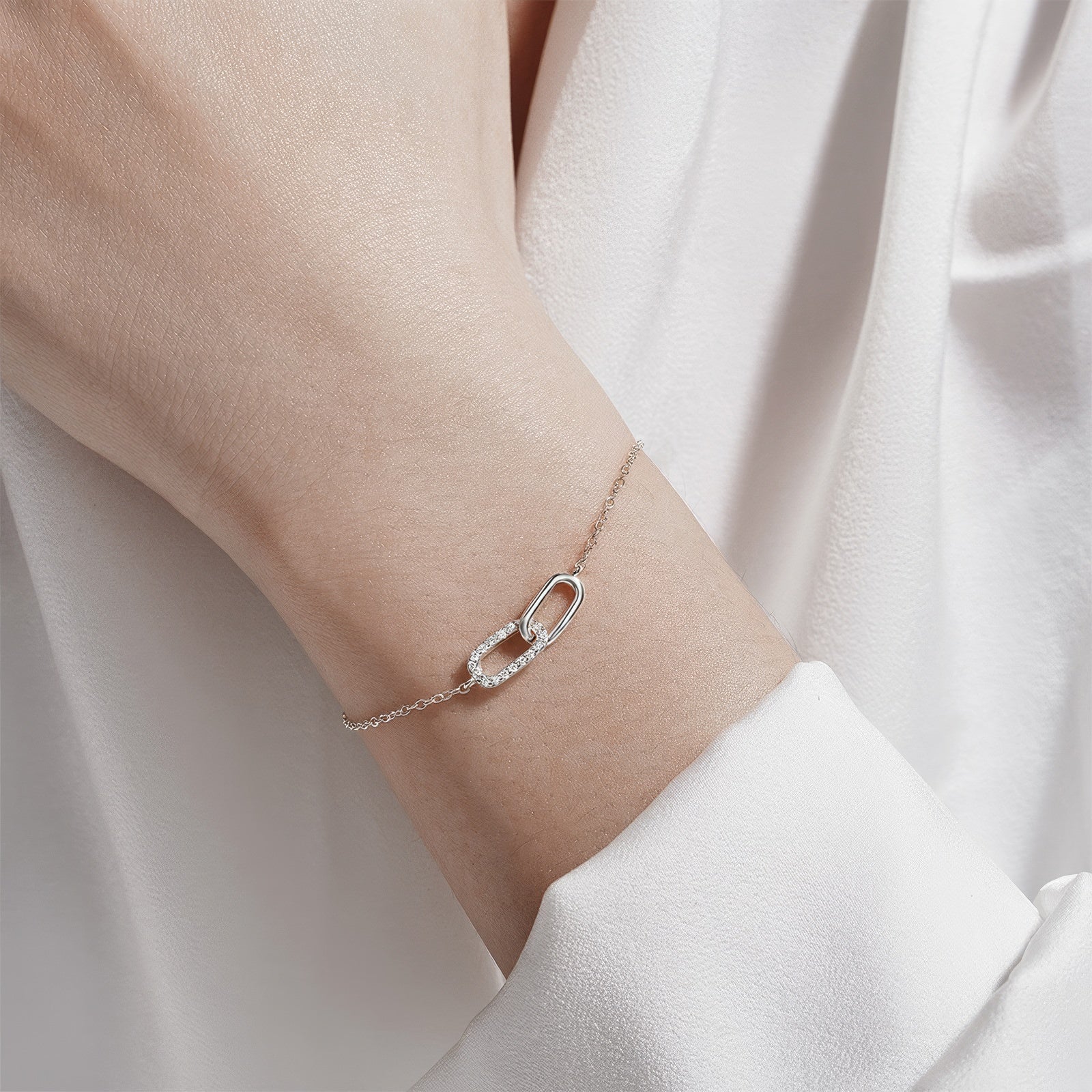 Interlocking zirconia link bracelet in 925 sterling silver with two oval charms—one pavé zirconia—adjustable chain, available in gold & silver plating