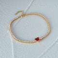 gold plated tennis bracelet with red heart-shaped crystal in the middle