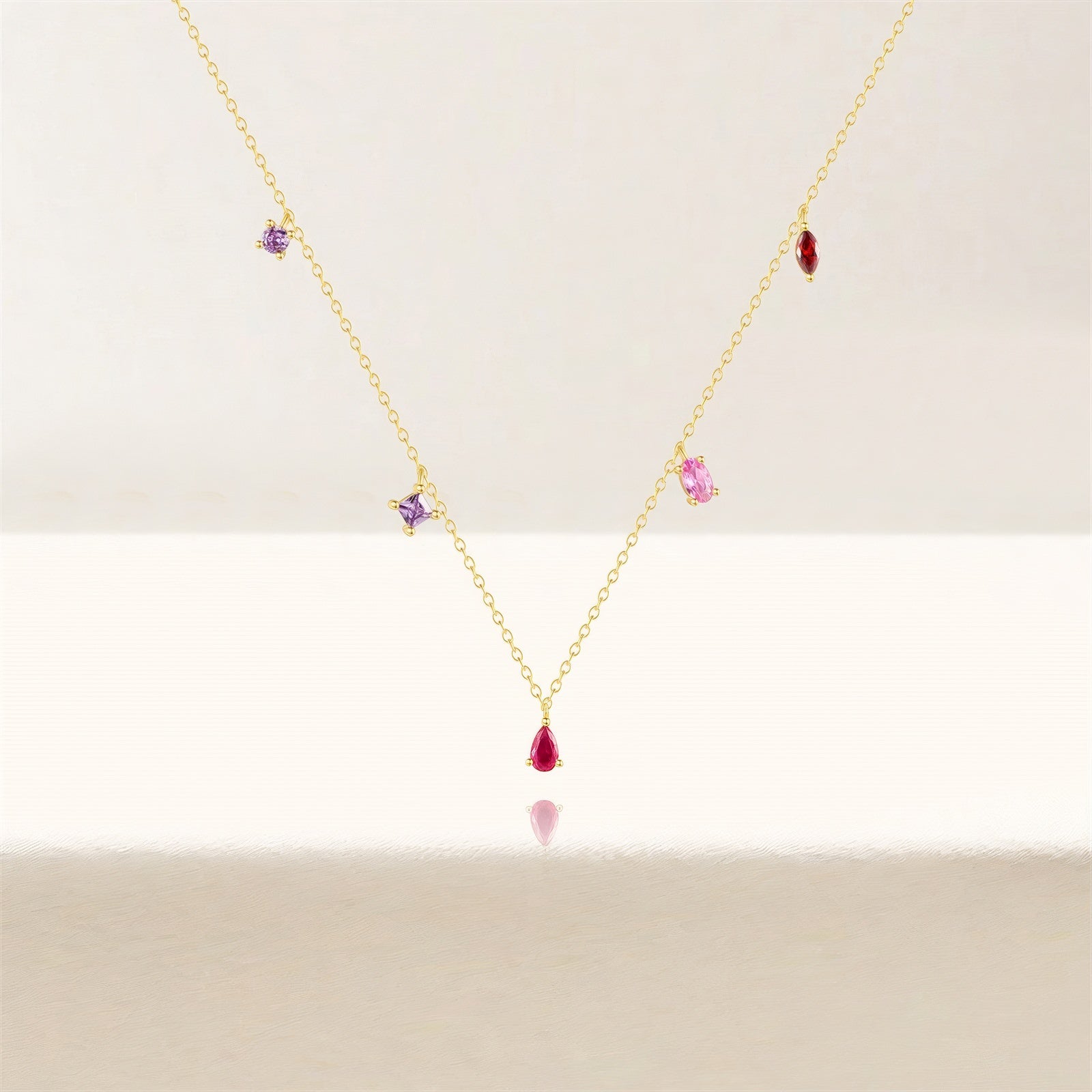 V-shape multicolor zirconia drop necklace in 925 sterling silver with 18K gold plating, adjustable chain, featuring red teardrop, pink baguette, marquise red, and purple square zirconia charms