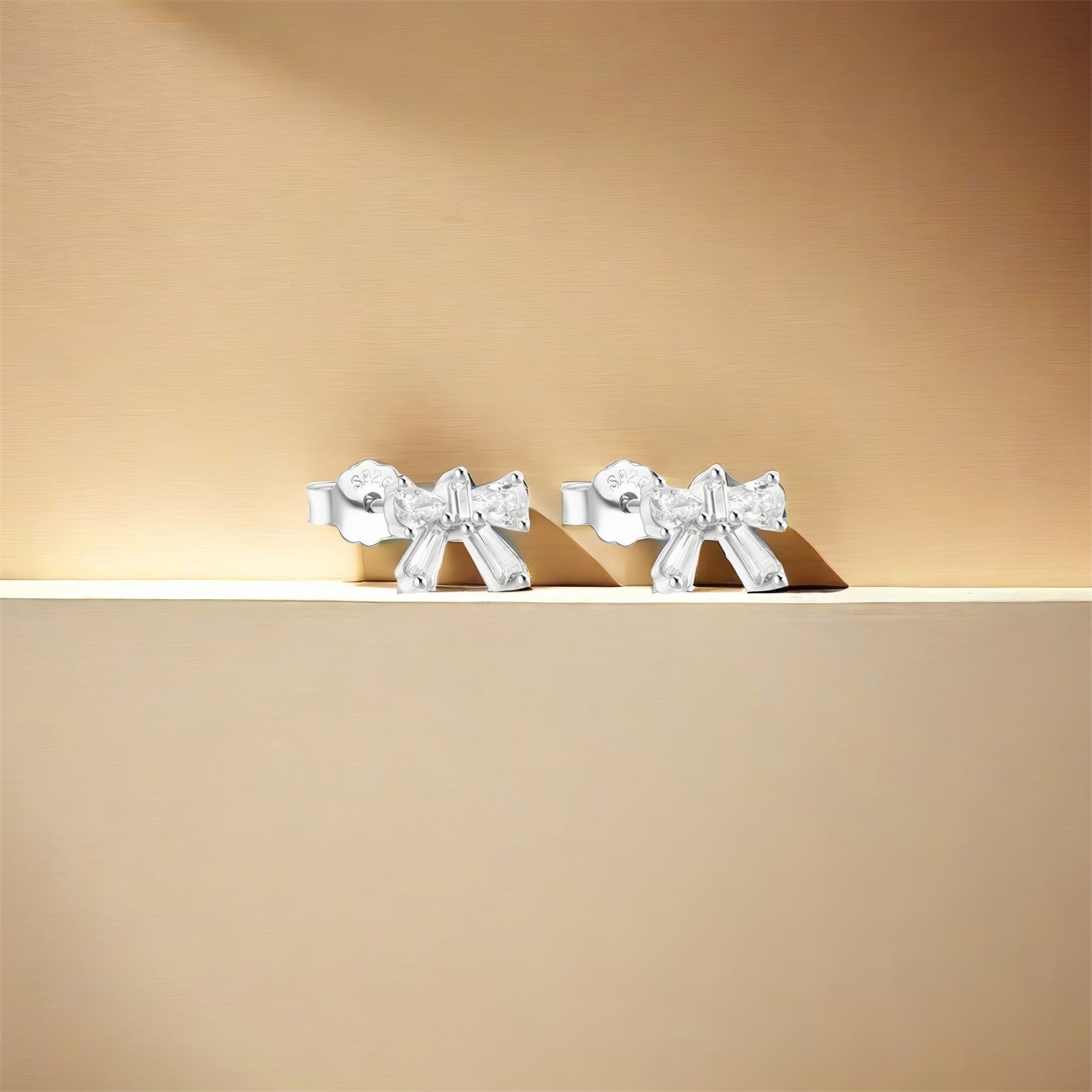 dainty bow shaped stud earrings in gold plated sterling silver made with zirconia crystals