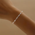 Gold tennis bracelet with alternating baguette and round zircon stones, 18K gold plated on copper, 3.5mm wide and 17cm long.