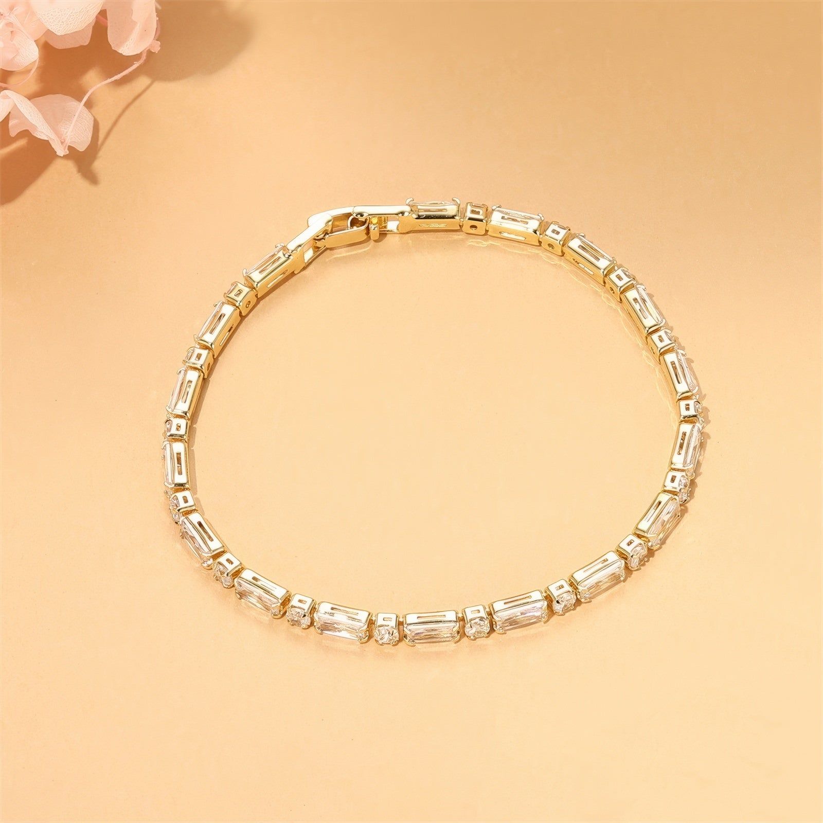 Gold tennis bracelet with alternating baguette and round zircon stones, 18K gold plated on copper, 3.5mm wide and 17cm long.