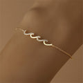 Gold bracelet with wave-shaped zircon design centerpiece on a sterling silver chain, finished with 18K gold plating.