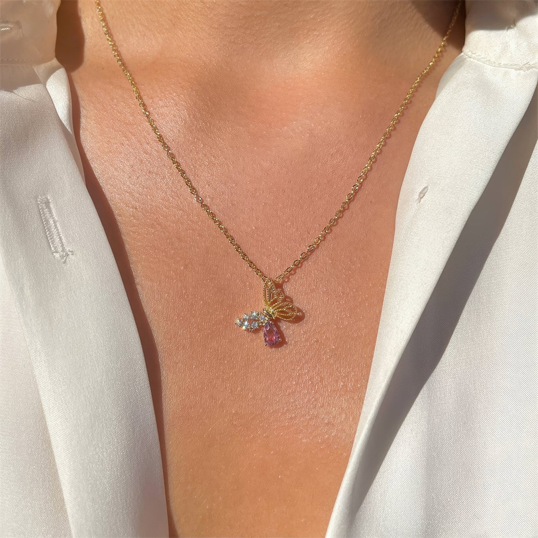 butterfly shaped pendant necklace pink and clear cubic zirconia crystal inclusions in gold plated cooper