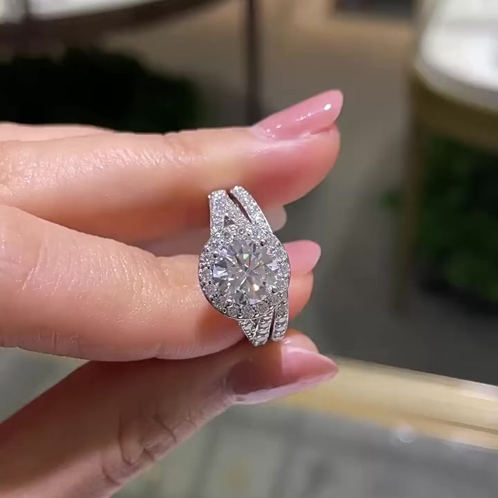 Sterling silver bridal ring set with round-cut moissanite center stone and halo, featuring a pavé split band and matching wedding band with moissanite stones