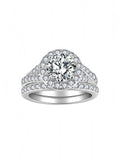 Sterling silver bridal ring set with round-cut moissanite center stone and halo, featuring a pavé split band and matching wedding band with moissanite stones
