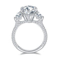 Sterling silver engagement ring with large pear-shaped moissanite center stone and heart-cut side stones, detailed with round moissanite on the band.