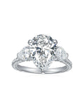 Sterling silver engagement ring with large pear-shaped moissanite center stone and heart-cut side stones, detailed with round moissanite on the band.